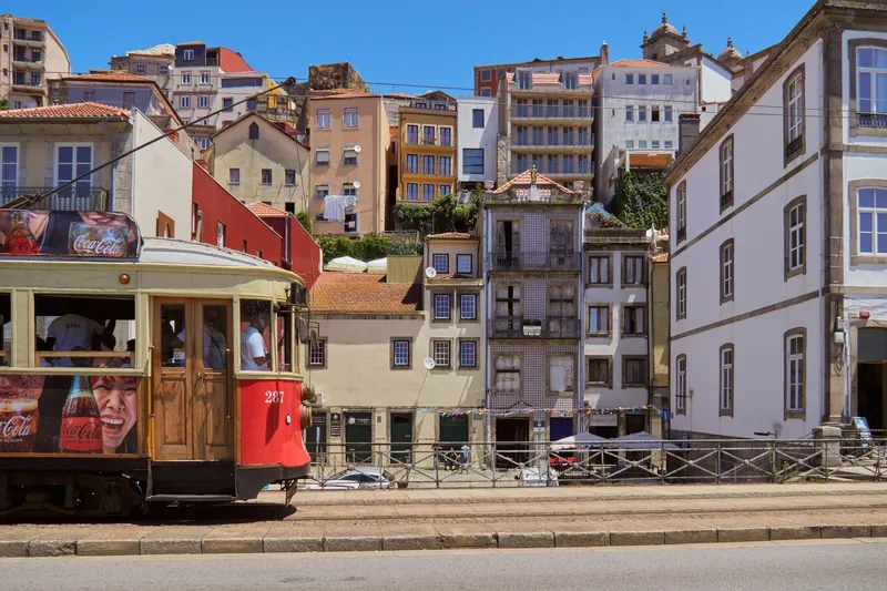 Straßenbahnwagen 287 an der Rua Nova da Alfândega in Porto vor dicht bebautem Hang mit Azulejo-Fassaden