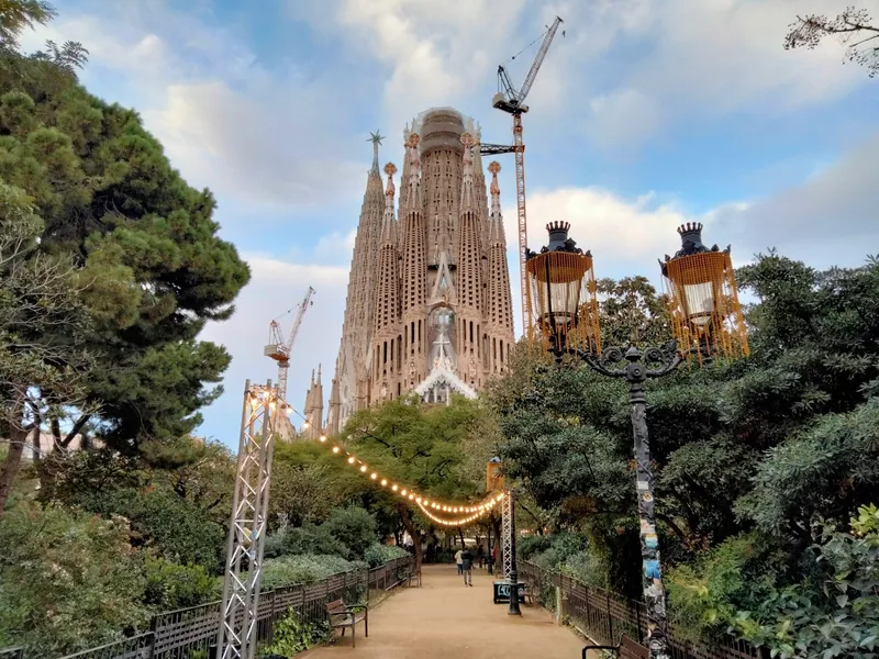 Passionsfassade der Sagrada Família in Barcelona mit Baukränen, von der Carrer de Sicília aus gesehen