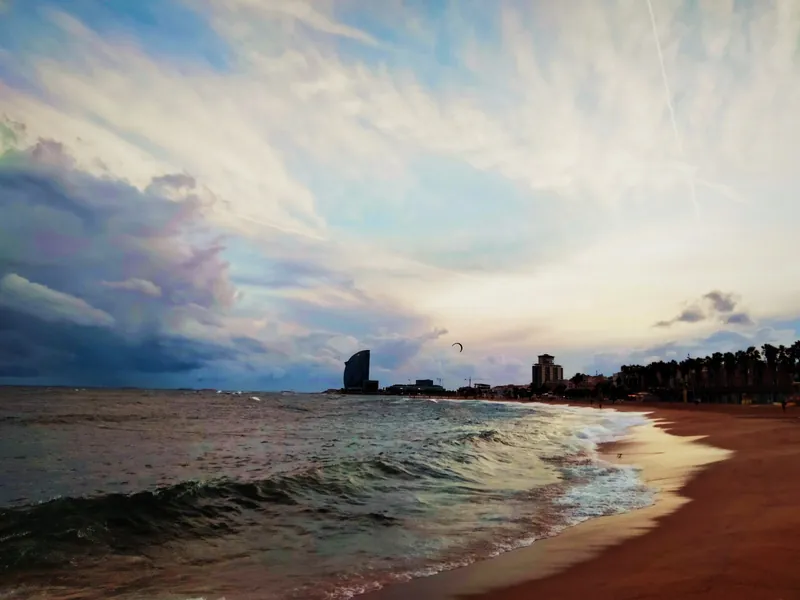 Stadtstrand Platja de la Barceloneta in Barcelona am Abend, im Hintergrund das Hotel W