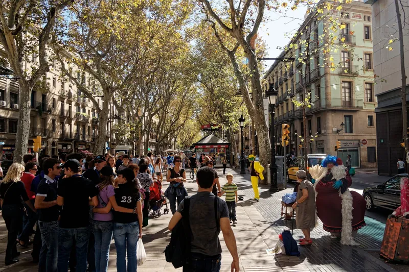 Flaniermeile Rambla dels Caputxins in Barcelona mit Platanenallee, Passanten und Straßenkünstlern
