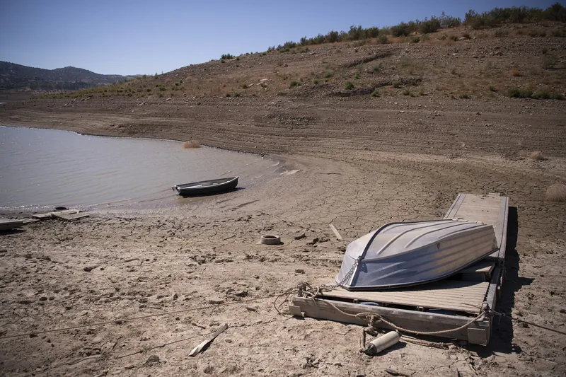 Tretboote und ein Steg auf dem trockengefallenen Grund des Stausees Embalse de La Viñuela in der Provinz Málaga, 19. August 2022 (Höhepunkt der andalusischen Dürre von 2022)