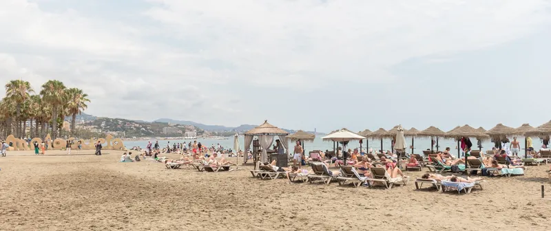 Stadtstrand Playa de la Malagueta in Málaga mit Liegen und Strohschirmen
