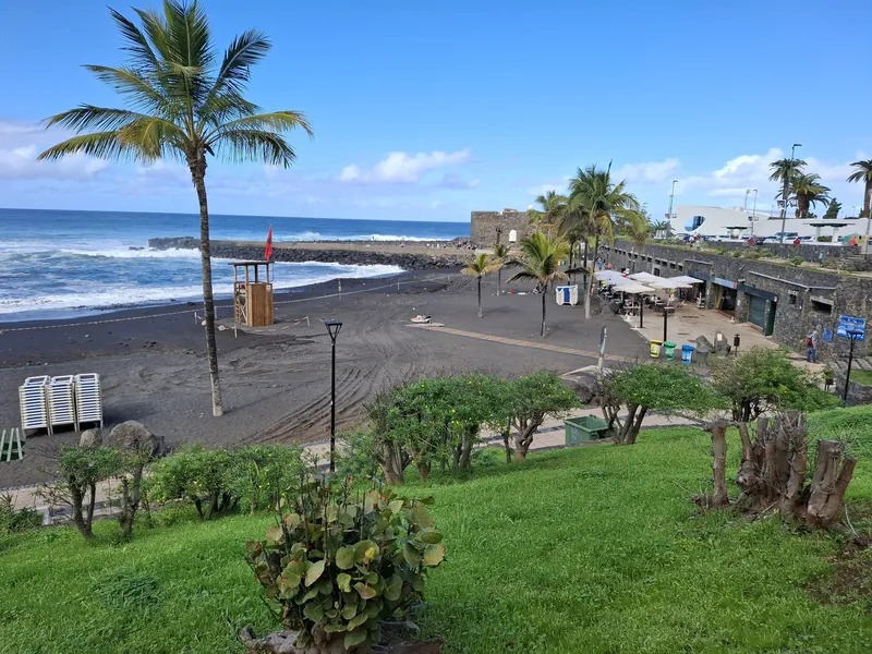 Playa Jardín in Puerto de la Cruz auf Teneriffa mit schwarzem Lavasand und dem Castillo de San Felipe
