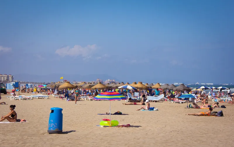 Stadtstrand Platja de la Malva-rosa in Valencia mit Strohschirmen und Liegen