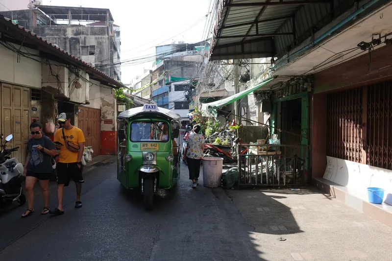 Lane in Bangkok's old Talat Noi quarter with a tuk-tuk and shophouses