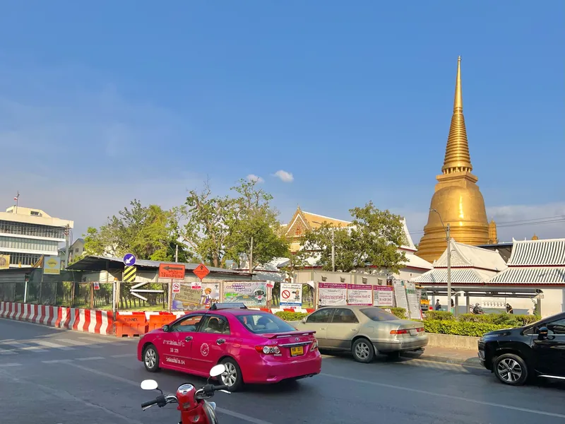 Rosafarbenes Taxi vor dem Tempel Wat Bowonniwet Wihan in Bangkok