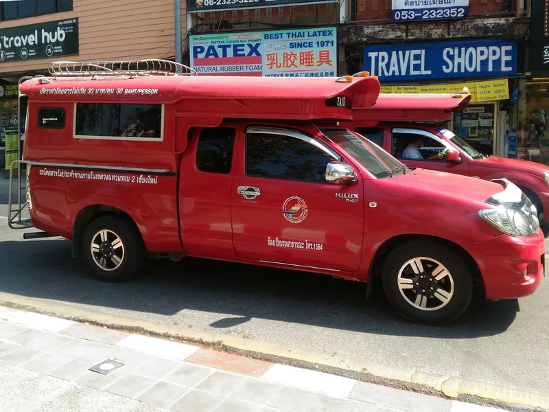 Roter Songthaew-Sammeltaxi-Pickup in Chiang Mai mit Festpreis-Aufschrift (30 Baht pro Person)