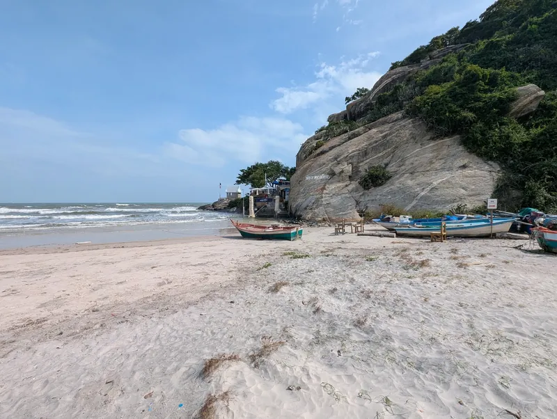Strand von Hua Hin mit Fischerbooten am Felsen