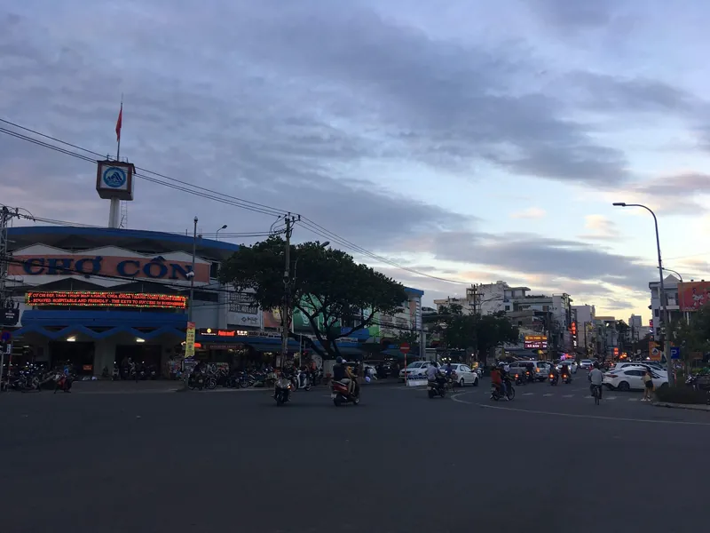 Motorroller an der Kreuzung vor dem Con-Markt in Da Nang in der Abenddämmerung