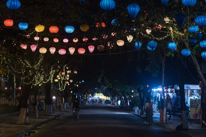 Mit bunten Lampions überspannte Straße in Hoi An nach Einbruch der Dunkelheit