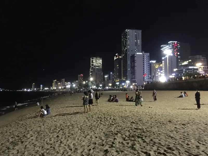 Durchgehende Hotel-Hochhauszeile direkt am Stadtstrand von Nha Trang bei Nacht (dichte Bebauung der Küstenlinie)